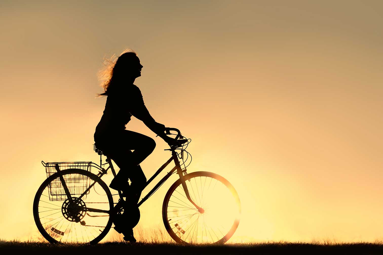 woman riding bike at sunset