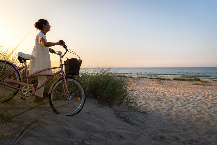 A woman with a bike on the beach