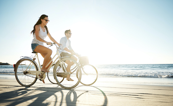 couple biking on beach