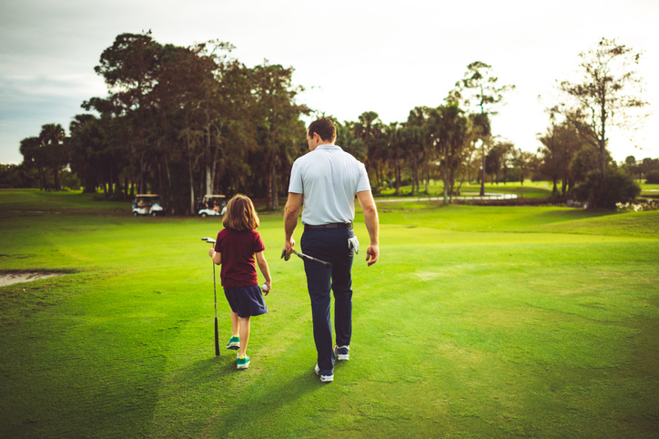 A father and daughter on a golf course